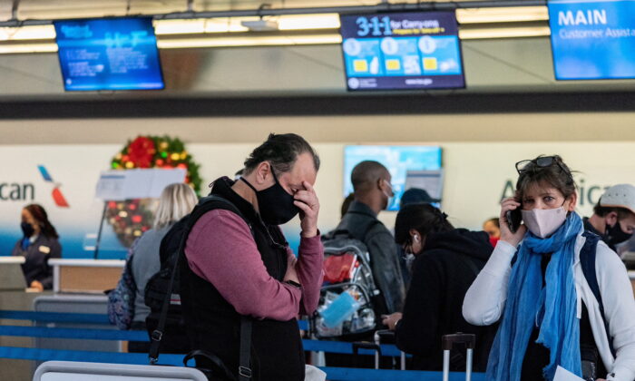 Passengers line up at John F. Kennedy International Airport during the spread of the Omicron coronavirus variant in Queens, New York City, U.S., December 26, 2021. REUTERS/Jeenah Moon