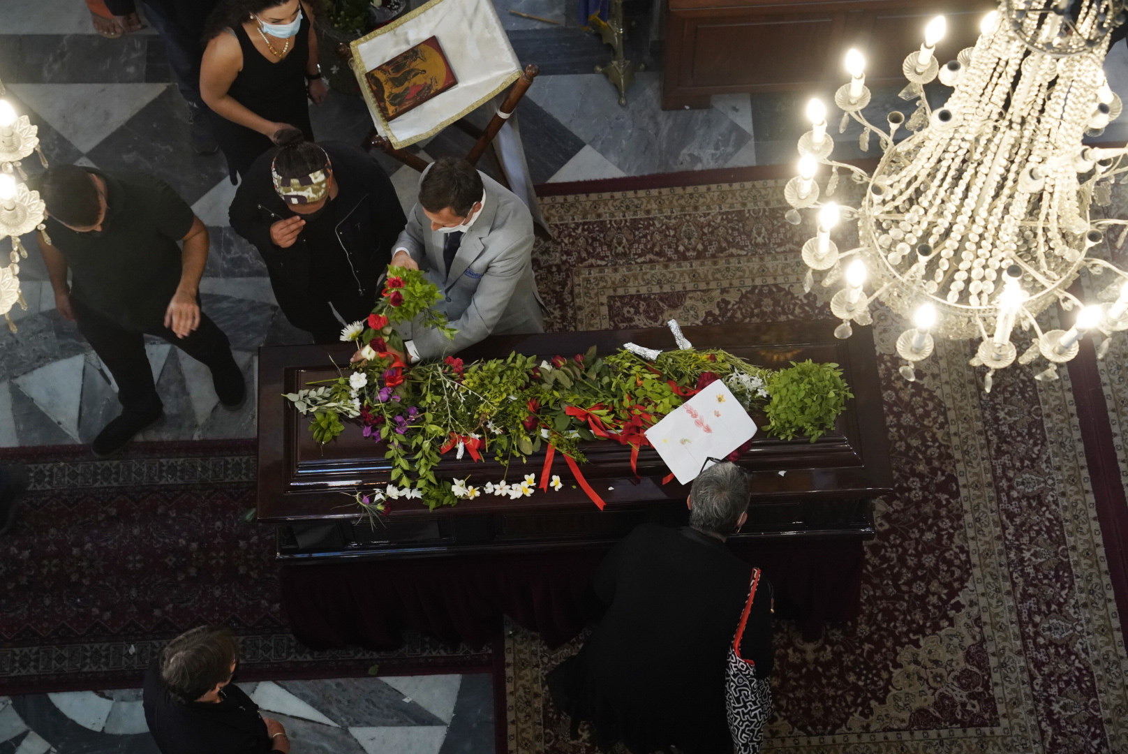 Κόσμος αποτίει φόρο τιμής αφήνοντας λουλούδια στο φέρετρο με τη σορό του Μίκη Θεοδωράκη στον Μητροπολιτικό Ναό των Εισοδίων της Θεοτόκου στα Χανιά , όπου εκτίθεται σε λαϊκό προσκύνημα , Πέμπτη 9 Σεπτεμβρίου 2021. Στις 13:00, η σορός με πομπή αυτοκινήτων θα μεταφερθεί στον ιερό ναό του Αγίου Νικολάου στο χωριό Γαλατάς, όπου σε στενό κύκλο εντός του ναού θα ψαλεί η εξόδιος ακολουθία και η ταφή του θα γίνει στο κοιμητήριο του χωριού. ΑΠΕ-ΜΠΕ/ΔΗΜΟΣ ΧΑΝΙΩΝ/ΠΕΤΡΟΣ ΠΑΤΤΑΚΟΣ/POOL