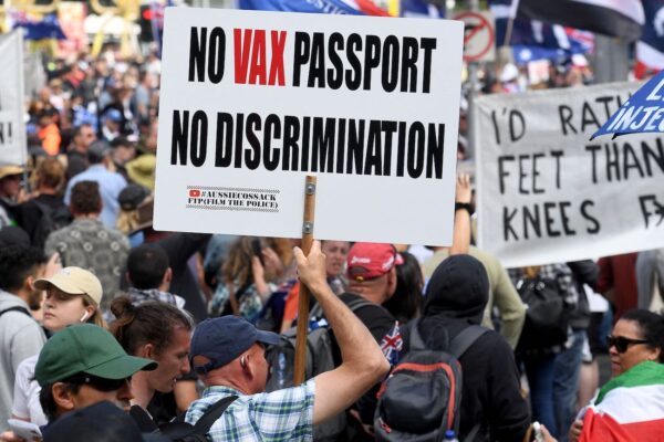 A protester holds up a placard during a rally against new pandemic laws and vaccination mandates in Melbourne on December 4, 2021. (Photo by William WEST / AFP) (Photo by WILLIAM WEST/AFP via Getty Images)